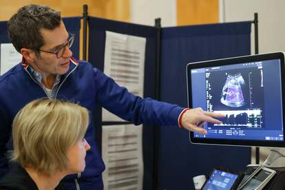 Ein Arzt erläutert einer Seminarteilnehmerin ein Ultraschallbild